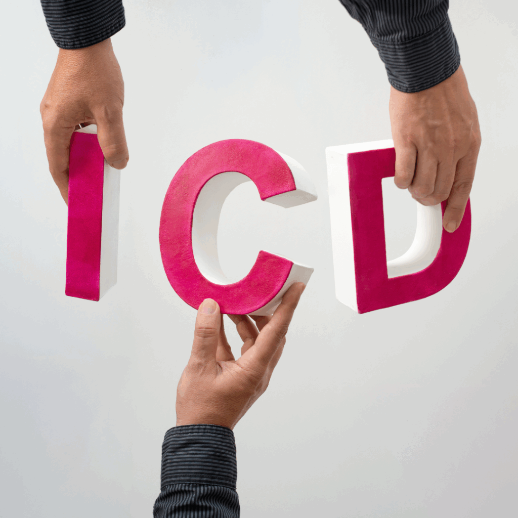 This image shows three hands holding large 3D letters spelling “ICD.” The letters are pink with white edges, and the people are wearing dark, striped shirts.